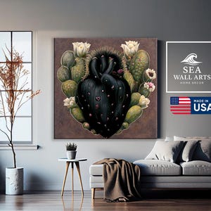 May include: A canvas wall art piece featuring a heart-shaped cactus design with a dark center and green and white accents. The artwork includes white flowers and small pink details. The image also includes the text "SEA WALL ARTS HOME DECOR" and "MADE IN USA".