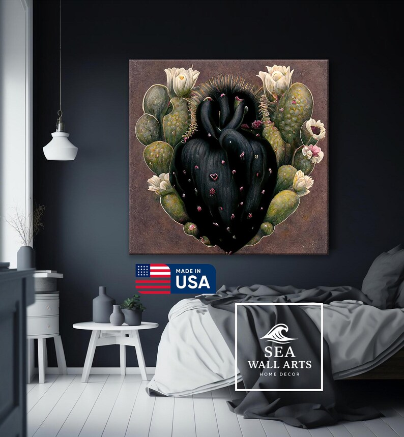May include: A canvas wall art piece featuring a heart-shaped cactus design. The artwork showcases a dark, textured heart shape surrounded by green cacti and white flowers. The words "MADE IN USA" are visible.