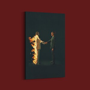 Puede incluir: Impresi&oacute;n en lienzo que representa a dos figuras con trajes estrech&aacute;ndose la mano sobre un fondo oscuro. Una figura est&aacute; en llamas, la otra no. La obra de arte tiene una cualidad surrealista y dram&aacute;tica.