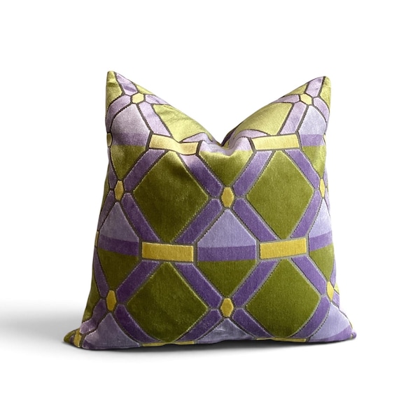 May include: A square throw pillow featuring a geometric pattern of interlocking diamonds and rectangles. The design consists of olive green, lavender, and chartreuse yellow velvet fabric sections stitched together to form a repeating grid.