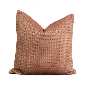 Puede incluir: Un cojín decorativo cuadrado con un patrón geométrico en tonos óxido y beige. El cojín tiene una apariencia texturizada y una forma clásica y elegante, perfecto para agregar un toque de calidez y estilo a cualquier espacio habitable. Mide aproximadamente 45 cm x 45 cm.