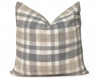 May include: Square throw pillow with a plaid pattern in shades of gray, beige, and white. The pillow has a soft, textured appearance and a classic design, suitable for home decor.