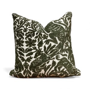 Könnte beinhalten: Ein dekoratives quadratisches Kissen mit einem dunkelgrünen und weißen Blumen- und Tiermuster. Das Kissen hat ein detailliertes Design aus Blumen, Blättern und stilisierten Kreaturen. Das Kissen ist ein Einrichtungsgegenstand.