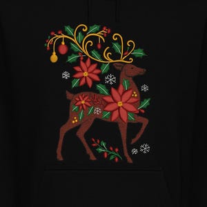 May include: Black hoodie featuring an embroidered reindeer design. The reindeer is adorned with red poinsettias, green holly, and gold accents. Snowflakes and ornaments complete the festive holiday theme.