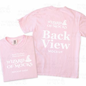 May include: Two light pink t-shirts. One is folded, displaying the text "WIZARD OF MOCKS" and "MOCKUP SHOP". The other is unfolded, showing the back with the text "Back View MOCKUP" and "WIZARD OF MOCKS".
