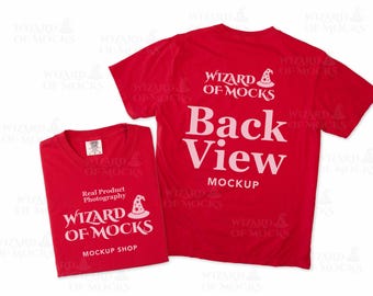 Puede incluir: Dos camisetas rojas de manga corta. La camiseta doblada presenta el texto blanco "Real Product Photography WIZARD OF MOCKS MOCKUP SHOP" con un icono de sombrero de mago. La camiseta desplegada muestra "WIZARD OF MOCKS" y "Back View MOCKUP".