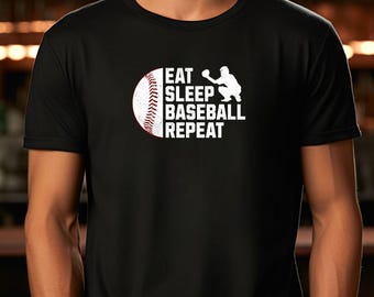 May include: Black t-shirt with the text "EAT SLEEP BASEBALL REPEAT" in white. A baseball and a baseball player silhouette are also in the design. The baseball is red and white.