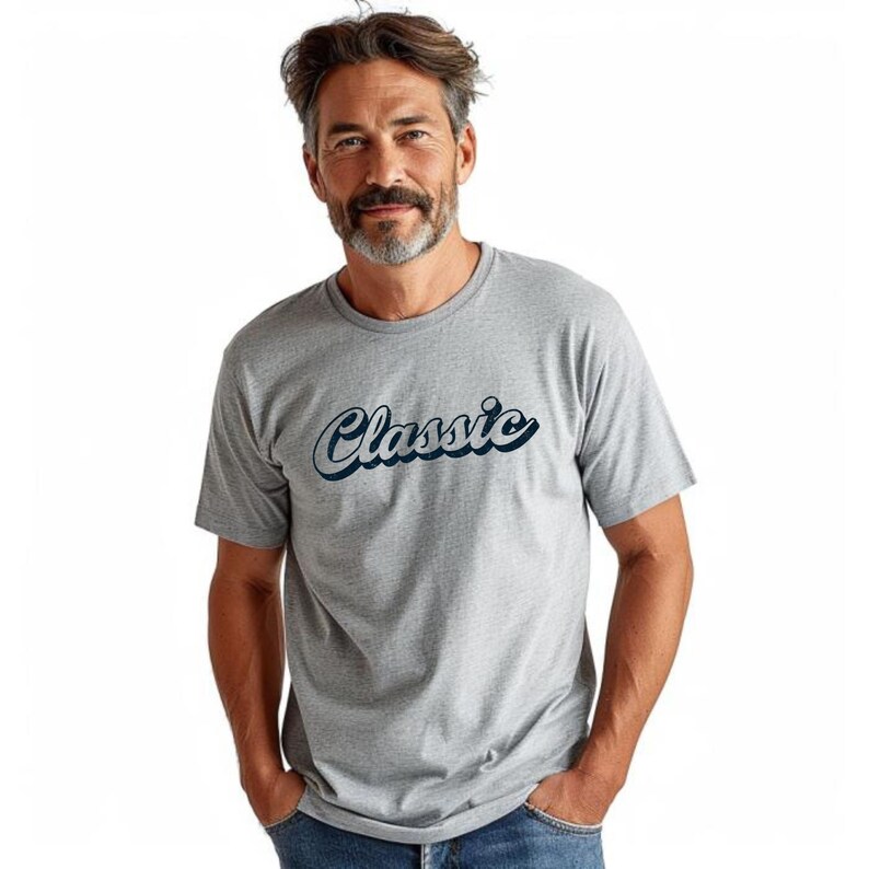 May include: A gray t-shirt with the word "Classic" in a cursive font. The text is in white with a dark blue outline. The shirt has short sleeves and a crew neck.