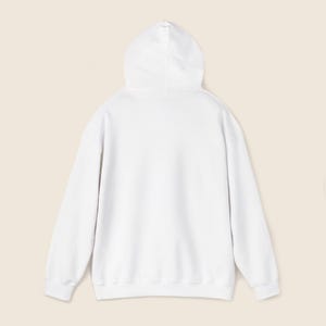 May include: A white hoodie with a drawstring hood. The back view of the sweatshirt shows the hood and the long sleeves. The hoodie is made of a soft, comfortable material.