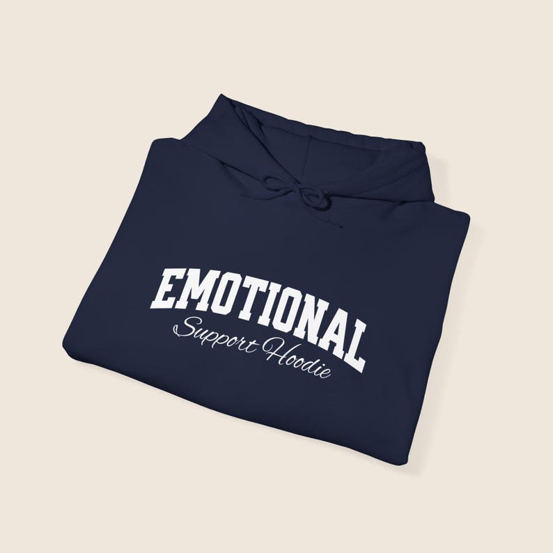 May include: Navy blue hoodie with the words "EMOTIONAL" in bold white letters arched across the top, and "Support Hoodie" in a script font below. The hoodie has a drawstring hood.