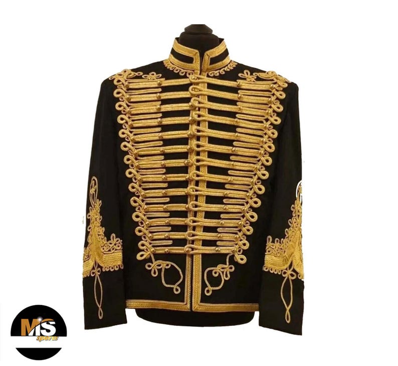 May include: Black military-style jacket with gold-colored decorative trim. The jacket features a high collar and ornate gold rope detailing across the chest and sleeves. The sleeves have gold embroidery. The jacket is displayed on a black mannequin head.