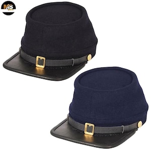 Könnte beinhalten: Zwei Kepi-Hüte im Stil des Bürgerkriegs. Einer ist marineblau, der andere ist schwarz. Beide haben ein schwarzes Lederschild, einen Lederriemen mit goldener Schnalle und goldene Knöpfe. Die Hüte sind aus einem wollähnlichen Material.