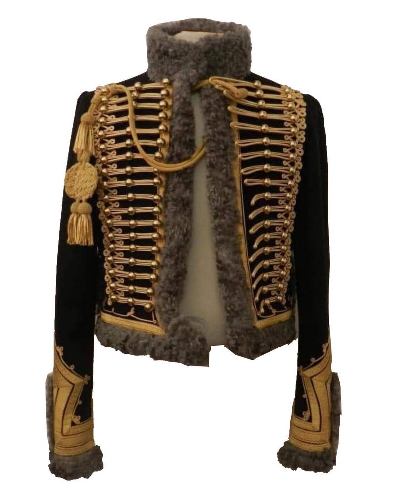 May include: A black cropped jacket with gold trim and accents, including buttons, tassels, and decorative embroidery. The jacket features a high collar and faux fur trim around the neck and cuffs. A stylish military-inspired garment.