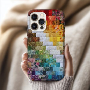 Könnte beinhalten: Eine farbenfrohe Handyhülle mit einem Patchwork-Design. Die Hülle zeigt eine lebendige Farbpalette, darunter Rot, Orange, Gelb, Grün, Blau und Lila. Das Design besteht aus kleinen, rechteckigen Stoffstücken, die ein strukturiertes Aussehen erzeugen.