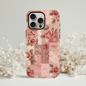 May include: A phone case with a patchwork design featuring pink roses and floral patterns. The case has a rectangular shape with rounded corners and a camera cutout. The color palette includes shades of pink, red, and cream.