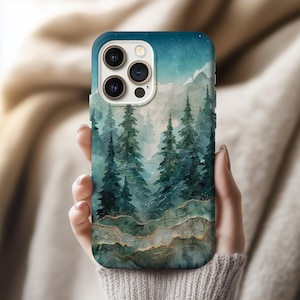 May include: A smartphone case featuring a watercolor landscape of a forest and mountains. The design includes shades of blue, green, and gold, with a starry sky. The case has a glossy finish and a protective design.