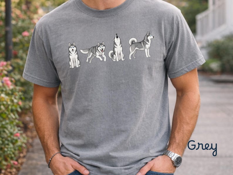 May include: Grey t-shirt featuring a graphic of a husky dog in various poses. The design includes a sitting, walking, howling, and standing husky. The word "Grey" is printed in the bottom right corner.