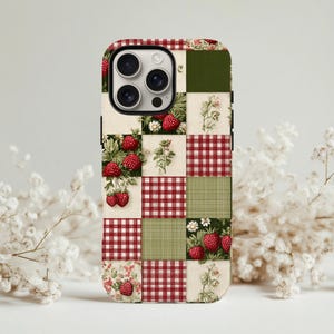 Könnte beinhalten: Handyhülle mit Patchwork-Design mit Erdbeeren, floralen Mustern und rot-weiß karierten Karos. Die Hülle hat eine Mischung aus grünen, roten und cremefarbenen Quadraten. Die Handyhülle ist für ein Smartphone konzipiert.