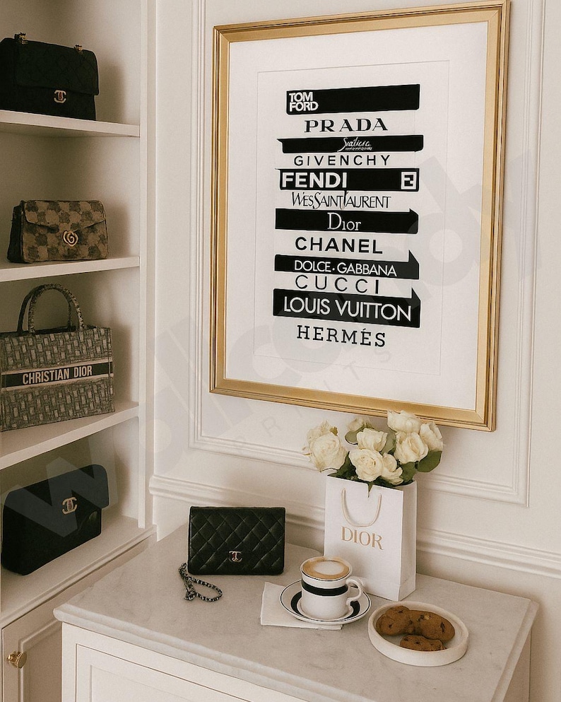 May include: A gold-framed print displaying luxury brand logos such as Prada and Chanel. A Dior shopping bag with white roses sits on a marble surface. A black quilted leather handbag and coffee with biscuits are also present. Designer handbags are on a shelf.