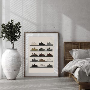 K&ouml;nnte beinhalten: Ein gerahmter Druck mit einer Sammlung von Turnschuhen, die auf Regalen ausgestellt sind. Die Turnschuhe sind in verschiedenen Farben erh&auml;ltlich, darunter Schwarz, Beige und Braun. Das Kunstwerk ist vor einem neutralen Hintergrund platziert, mit einer Pflanze in einer wei&szlig;en Vase links.