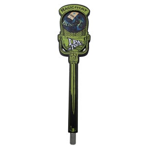 May include: A light green and black beer tap handle shaped like a vintage microphone. The top features the text Magic Hat and Blind Faith, while the center displays the text IPA ON TOUR in white lettering against a green textured background.