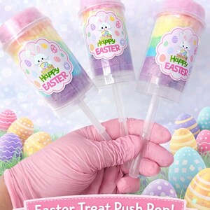 May include: Three push pop containers filled with rainbow cotton candy, each with a pink lid and a label that says "Happy Easter" with a bunny and eggs. The image also includes Easter eggs and the text "Easter Treat Push Pop! Cotton Candy."