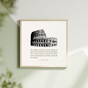 May include: A framed print featuring a black and white illustration of the Colosseum in Rome. The print includes text from St. Clement of Rome, a religious quote about love and sacrifice. The artwork is set against a neutral background.