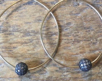 Può includere: Orecchini a cerchio in argento con ciondolo a sfera di diamanti neri.