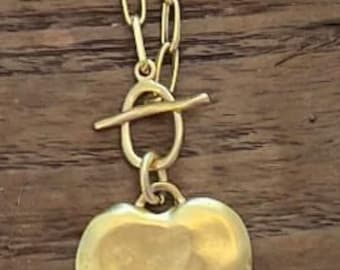 Può includere: Collana color oro con pendente a forma di cuore. La collana presenta una chiusura a toggle e una catena con maglie ovali. Il pendente a forma di cuore ha una superficie strutturata.