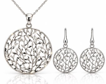 May include: A silver-toned jewelry set consisting of a pendant necklace and matching drop earrings. Each piece features a circular frame containing an intricate, openwork design of interconnected branches and leaves, accented with small clear stones.