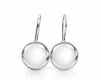 May include: A pair of silver-toned drop earrings featuring smooth, circular, polished metal discs suspended from curved ear wires. The earrings have a reflective, metallic finish and a simple, rounded design that hangs vertically.
