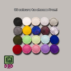 May include: A collection of twenty colorful, circular bottle stoppers. The stoppers are arranged in rows and columns, showcasing a variety of colors including black, white, yellow, blue, red, and purple. Text at the top reads "20 colours to choose From!"