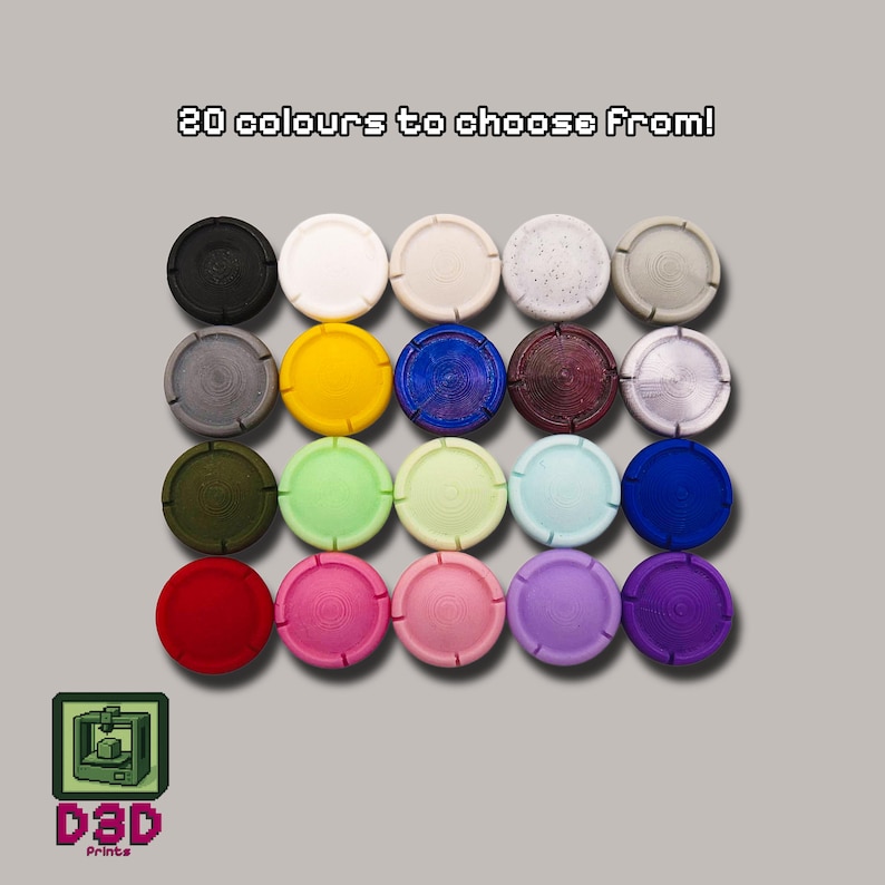 May include: A collection of twenty colorful, circular bottle stoppers. The stoppers are arranged in rows and columns, showcasing a variety of colors including black, white, yellow, blue, red, and purple. Text at the top reads "20 colours to choose From!"