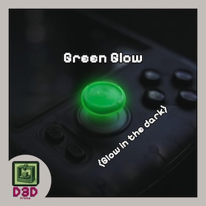 May include: A close-up of a green, glowing joystick button on a black game controller. The text "Green Glow" is above the button, and "{Glow in the dark}" is below. A logo for D3D Prints is in the lower left corner.