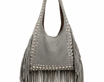 Puede incluir: Un bolso hobo gris con una sola correa para el hombro, un cuerpo en forma de U y largos flecos en la parte inferior y los laterales. El panel frontal está decorado con filas de tachuelas metálicas plateadas redondas que enmarcan los bordes.