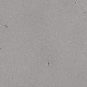 The image is a close-up of a grey concrete surface with small holes or scratches visible.