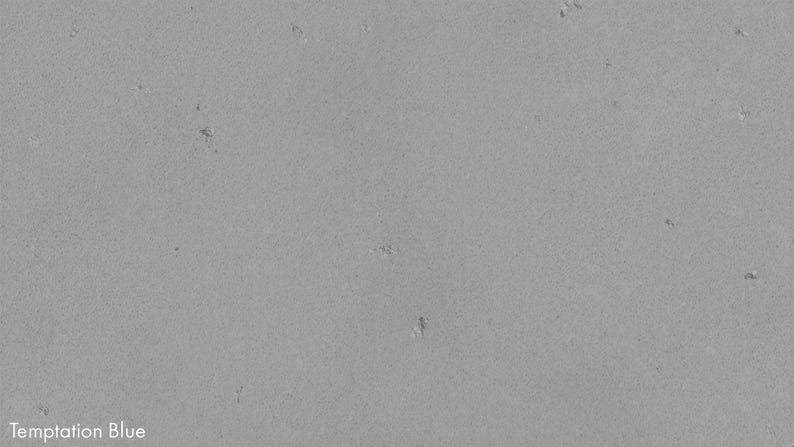 The image is a close-up of a grey concrete surface with small holes or scratches visible.