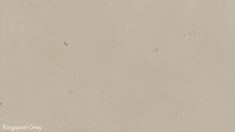 The image is a plain, light beige surface with small, irregularly shaped holes or specks scattered across it.
