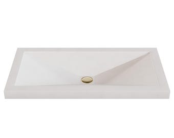 May include: A rectangular white bathroom sink with a flat rim and a sloped basin that angles toward a central circular drain. The drain features a polished gold-toned metal cover, providing a distinct contrast against the matte white surface.