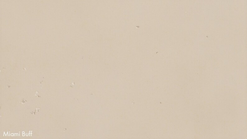 The image is a plain beige wall with some small white specks scattered across it.