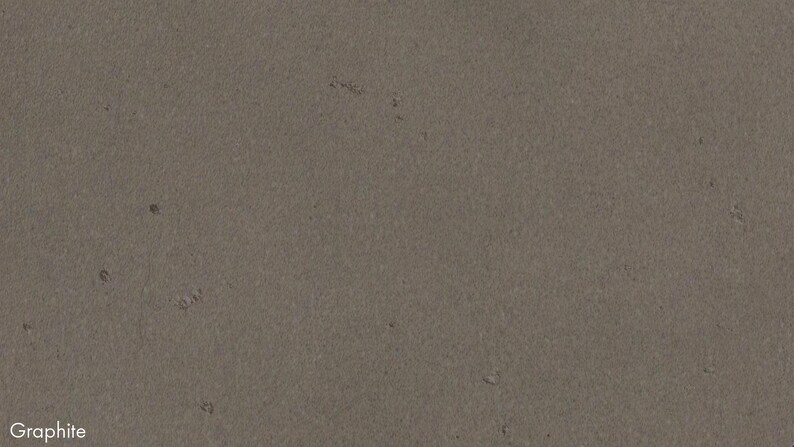 The image is a close-up of a grey, textured surface, possibly a piece of graphite or a similar material.