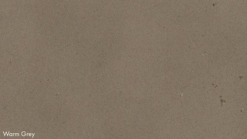 The image is a close-up of a textured surface, possibly a wall or a piece of fabric, with a warm grey color.