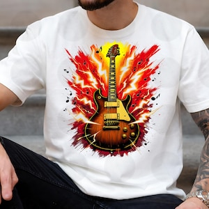 Op de afbeelding: Wit T-shirt met een gedetailleerde illustratie van een bruine elektrische gitaar met gele accenten. De gitaar staat tegen een achtergrond van rode en gele bliksemflitsen en muzieknoten, wat een dynamisch ontwerp creëert.