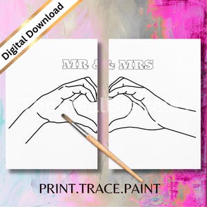 May include: Two white canvases with black line art of hands forming a heart, with the words "MR & MRS" above. A paintbrush rests on the canvas. The words "PRINT.TRACE.PAINT" are at the bottom. A gold diagonal banner reads "Digital Download".