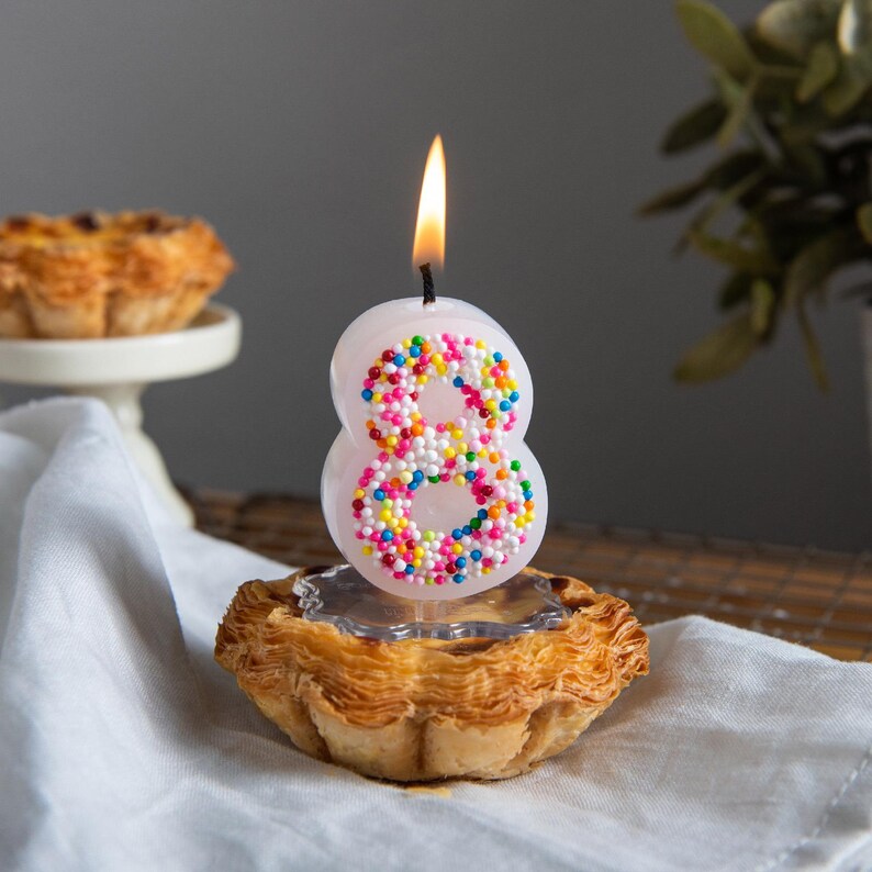 Lit sprinkles number 8 candle featuring candy-inspired details, designed for fun and colorful birthday cake decor.
