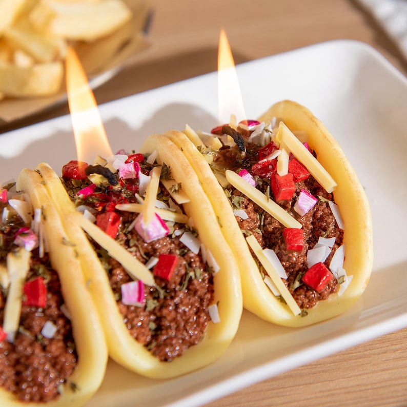 The realistic food novelty tacos candle comes in three taco and they are burning with bright flames, soy wax shells detailed with beef, cheese, and veggie toppings. Fun Mexican-inspired novelty candle and quirky centerpiece gift.