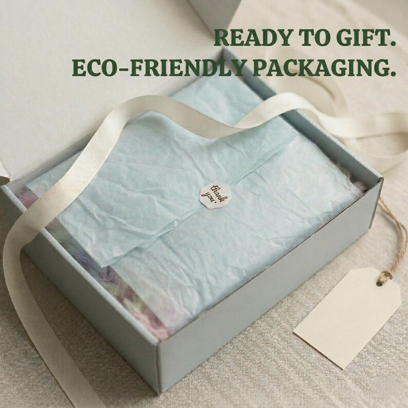 May include: A light blue gift box with a white ribbon and a blank tag. Inside, the box contains tissue paper and a small sticker that says "thank you". The text "READY TO GIFT. ECO-FRIENDLY PACKAGING." is printed above the box.