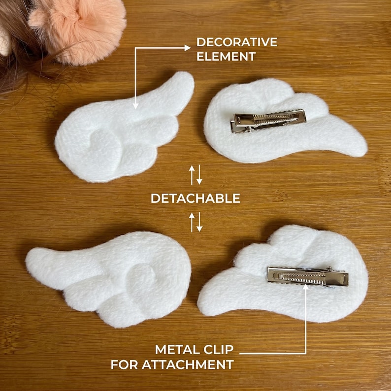 May include: White plush angel wing hair clips with metal clips for attachment. The decorative elements are detachable. The image shows two pairs of white plush angel wing hair clips, each with a metal clip on the back for easy attachment to hair.