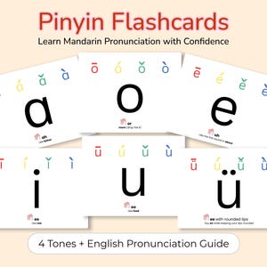 May include: A set of white Pinyin flashcards featuring the Mandarin vowels a, o, e, i, u, and ü. Each card displays the four tone marks in red, yellow, green, and blue, along with large black letters and English pronunciation guides below.