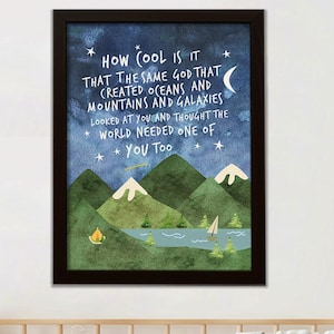 May include: Framed art print with a dark wood frame. The artwork features a watercolor landscape with mountains, a lake, and a sailboat. The text reads: "HOW COOL IS IT THAT THE SAME GOD THAT CREATED OCEANS AND MOUNTAINS AND GALAXIES LOOKED AT YOU AND THOUGHT THE WORLD NEEDED ONE OF YOU TOO."